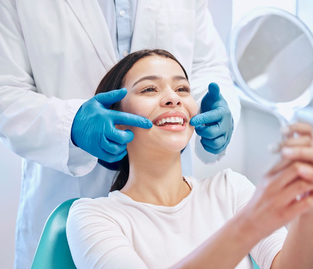 young woman checking her results in the dentists office
